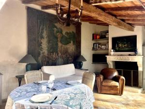 a dining room with a table and a painting on the wall at Logis de la Vau - Private pool - Quiet in Saint-Benoist-sur-Mer