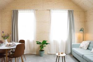 a living room with a blue couch and a table at NoSa Sleep, Sfeervol vakantiehuis in Grijpskerke in Grijpskerke +18 photos