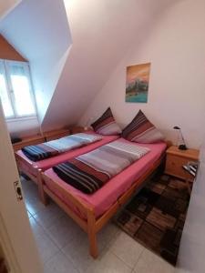 une petite chambre avec un lit dans un grenier dans l'établissement Haus Sissy, à Balatonkeresztúr