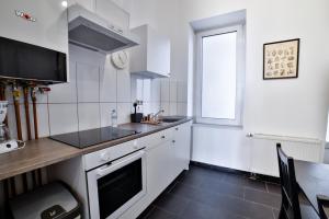 a white kitchen with a counter and a window at Altbauoase im Goethequartier in Bremerhaven