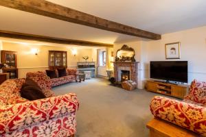 a living room with couches and a tv and a fireplace at H Oxencombe Farm House in Newton Abbot