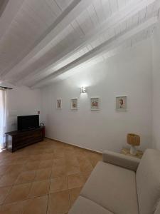 a living room with a couch and a tv at Appartamento il Paguro a Cala Francese in La Maddalena