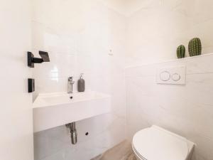 a white bathroom with a sink and a toilet at Casa Cappello in Hvar