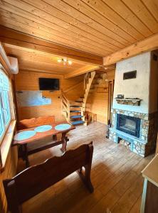 a large room with a table and a fireplace at Sielanka - Domki Całoroczne in Bezmiechowa Dolna +10 photos