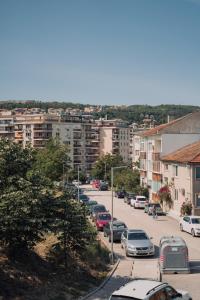 a city street with parked cars and buildings at ParkView Велико Търново in Veliko Tŭrnovo