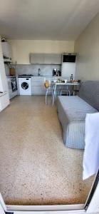 cocina con cama y mesa en una habitación en La Frégate Town Centre and Beach, en Le Grau-du-Roi