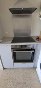 Un horno de estufa en una cocina blanca en La Frégate Town Centre and Beach, en Le Grau-du-Roi 27 fotos más