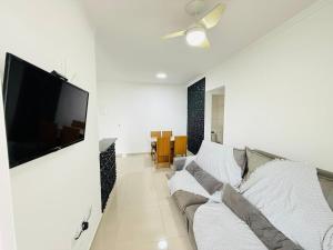 Refúgio Beira Mar Praia Grande في برايا جراندي: غرفة معيشة مع أريكة وتلفزيون بشاشة مسطحة