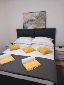 a large bed with yellow pillows on it at Apartman Marta in Klek +97 photos