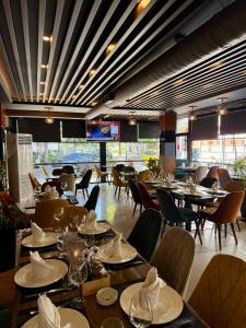a restaurant with tables and chairs and a television at Ujvara Hotel in Golem