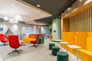 a waiting room with colorful chairs and tables at Tru by Hilton Chapecó - NOVO in Chapecó