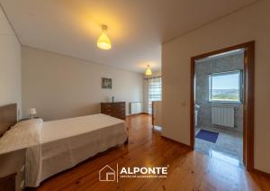 a bedroom with a bed and a large window at Casa da Escusa by ALPONTE in Caminha