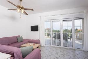 a living room with a purple couch and a balcony at Casa Marjardin Hanioti 2025 in Hanioti