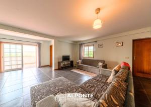 a living room with a couch and a tv at Casa da Escusa by ALPONTE in Caminha