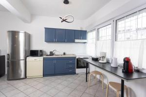 a kitchen with blue cabinets and a black counter top at Casa Marjardin Hanioti 2025 in Hanioti