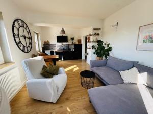 a living room with a couch and a chair at Burg & Tal Panorama in Riedenburg
