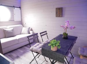a living room with a couch and a table with flowers at La Grande Pêcherie in Saint-Malo-de-Guersac