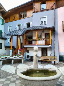 a building with a fountain in front of a building at Cà da Nello in Pellizzano