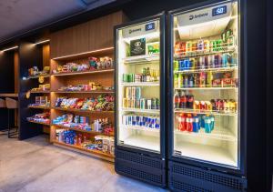 a refrigerator filled with lots of drinks in a store at Urbà Home Stay by Housi in Goiânia