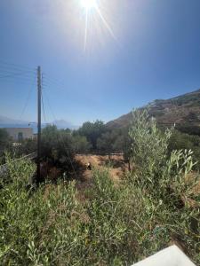 a view of a hill with the sun in the sky at Nikosgardenplacebythesea in Amorgos