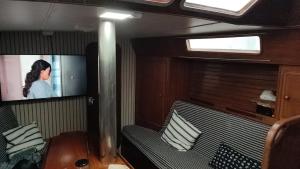 瓦伦西亚Romantic sailboat的一间配有沙发的房间和船上的电视