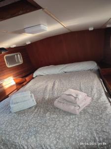 瓦伦西亚Romantic sailboat的船上的一张床位,上面有毛巾