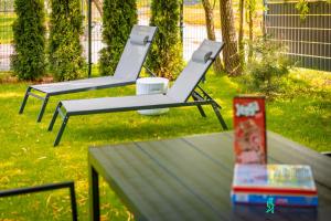two white chairs sitting on top of a table at Dom w Starkowie, Sauna i Balia in Starków