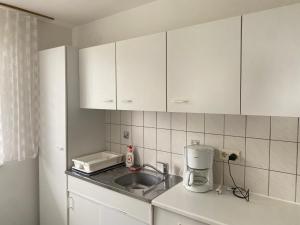 a kitchen with white cabinets and a sink at Seasons & Connections in Balatongyörök