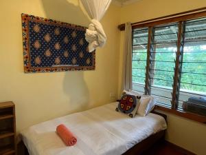 LushotoにあるMilemeleni Lodgeのベッドと窓のある小さな寝室