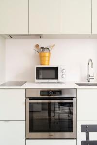 a microwave oven sitting on top of a stove in a kitchen at L'Escapade Carnot - Nancy centre Stanislas - 2Pers in Nancy