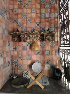 a tiled bathroom with a sink and a chair at Dar Michèle Djerba in Houmt Souk +25 photos