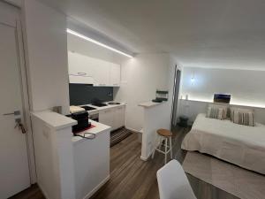 a small white room with a bed and a kitchen at New ! Rayuela San Pantaleo in San Pantaleo +12 photos
