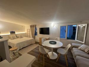 a room with a bed and a table and a couch at New ! Rayuela San Pantaleo in San Pantaleo