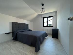 a bedroom with a bed and a window at Casa Tuno in Villanueva de Arosa