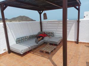 osoba leżąca na kanapie na patio w obiekcie Isleta del Moro TERRAZA VISTAS MAR Exclusiva 60 m2 WIFI w mieście La Isleta del Moro