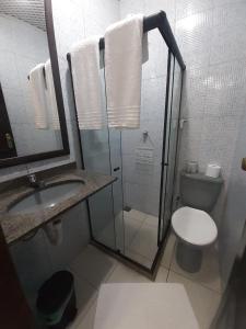 a bathroom with a shower and a toilet and a sink at Apartamento perto do Palácio de Cristal in Petrópolis