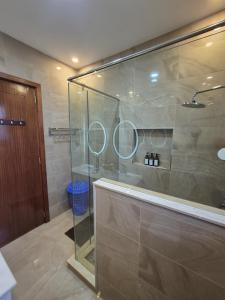 a bathroom with a glass shower with two mirrors at The Urban EcoLuxe Karen, Nairobi in Nairobi +84 photos
