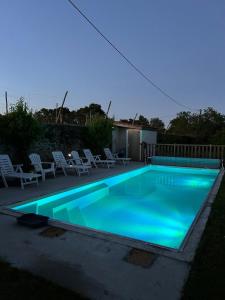 a swimming pool with blue lighting in a backyard at Le Colibri - Domaine de la Houblette in Challans +15 photos