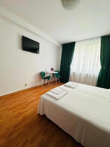 a bedroom with a large white bed and a table at Your Cozy Home in Piatra Neamţ +15 photos