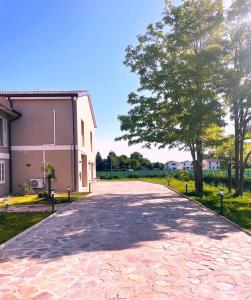 a cobblestone driveway leading to a building at Villa Iris in Imola