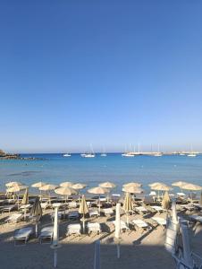 a beach with umbrellas and chairs and the water at Villetta Lu Sciardinu in Otranto