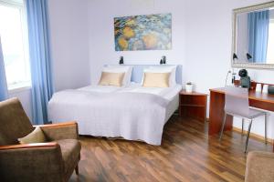 1 dormitorio con 1 cama, escritorio y sillas en Hotel Marena en Andenes