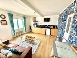 a living room with a couch and a table at La Bella Vita Briochine, cosy appartement in Saint-Brieuc