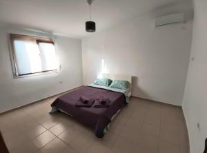 a bedroom with a bed in a white room at Summer house, Μονοκατοικία 120 in Eretria