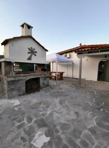 a building with a fireplace and a picnic table at Summer house, Μονοκατοικία 120 in Eretria