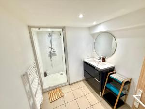 a bathroom with a sink and a shower and a mirror at La Bella Vita Briochine, cosy appartement in Saint-Brieuc