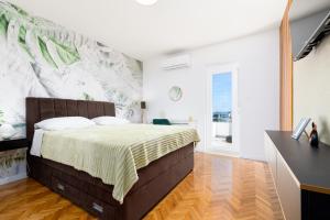 sypialnia z łóżkiem i ścianą z malowidłem w obiekcie Apartments Mate Balote 54 w Krku