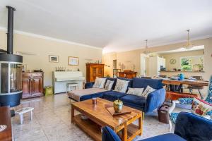 Una sala de estar con un sofá azul y una mesa. en Villa de L'Uba - Welkeys, en Toulon