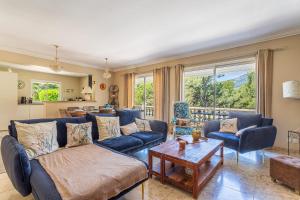 Una sala de estar con sofás azules y una mesa. en Villa de L'Uba - Welkeys, en Toulon