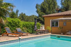 Una piscina con sillas y una mesa al lado de una casa. en Villa de L'Uba - Welkeys, en Toulon 17 fotos más